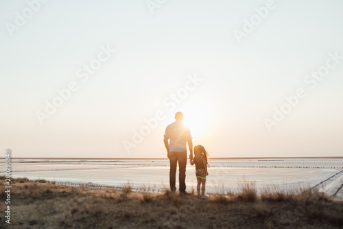 Young happy family walking along the seashore