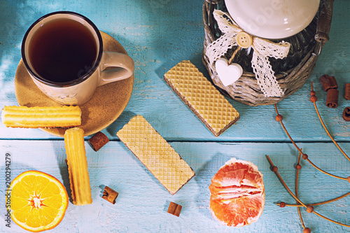 morning scene with cup of tea or coffee, Dutch cookie stroopwafel, Delfts blue souvenir, on blue table