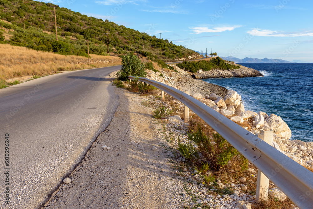 Asphalt road along sea on eastern side of Zakynthos island in sunny summer morning. Greece