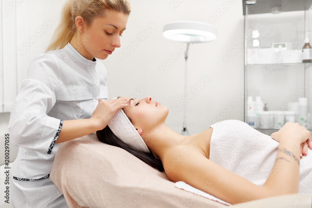 Beautiful woman having her face massaging and moisturizing in beauty salon. Beautiful woman having her face massaging and moisturizing in beauty salon.