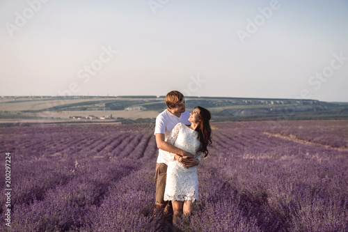Beautiful young coulpe walking against lavender fields and hills.