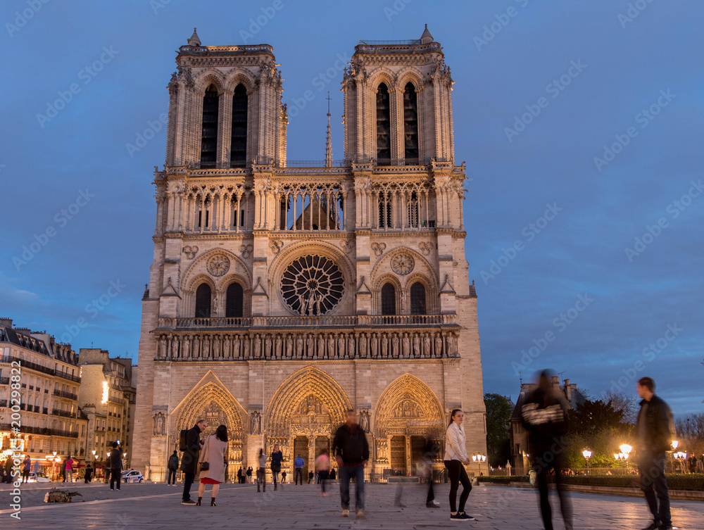 Notre Dame cathedral seen just after sunset, beautifully illuminated against the blue sky