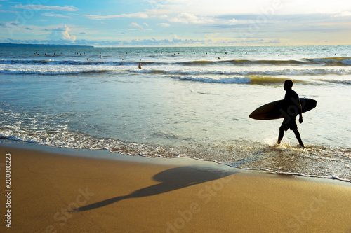 Surfer walk out ocean silho...
