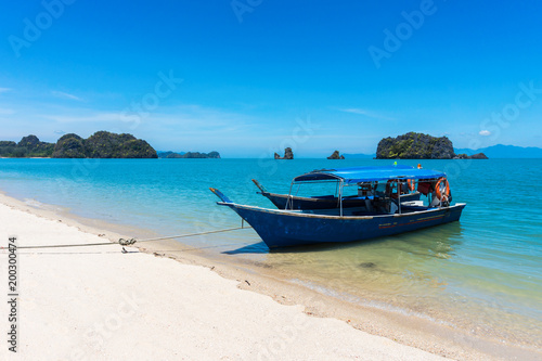 Old traditional wooden walking boats that tied the rope on the shore on the tropical beach in Malaysia