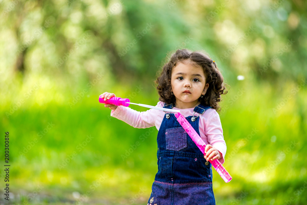 Portrait of cute girl blowing soap bubbles