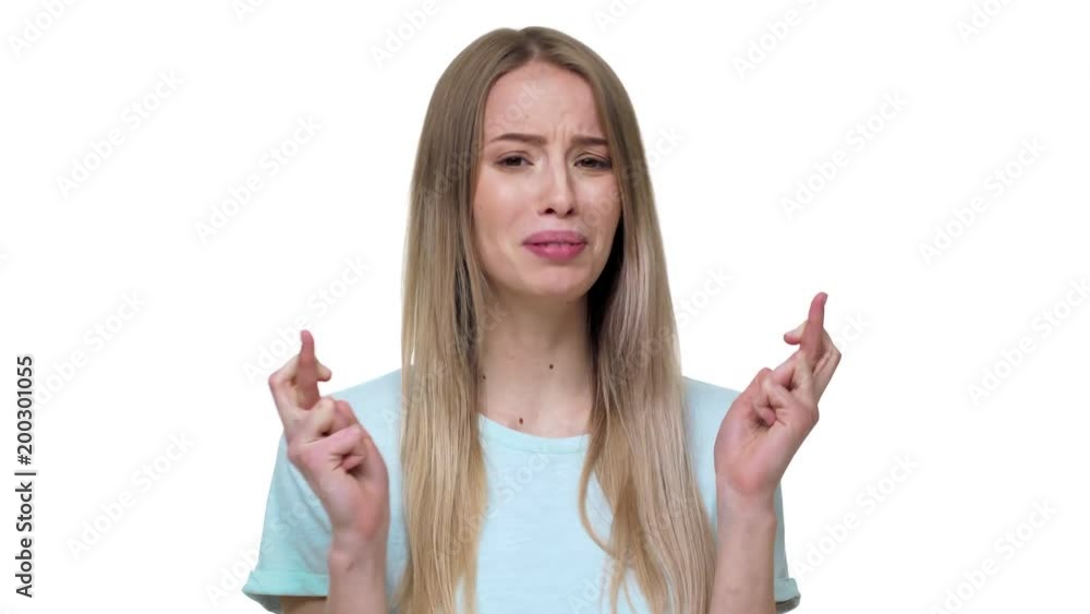 Portrait of woman keeping fingers crossed in praying pose and saying god please, isolated over white background closeup. Concept of emotions Portrait of woman keeping fingers crossed in praying pose and saying god please, isolated over white background closeup. Concept of emotions