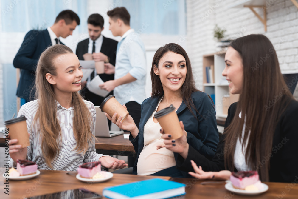 Three young beautiful girls communicate on coffee break and eat sweet cakes. Three young beautiful girls communicate on coffee break and eat sweet cakes.