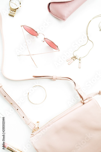 Pale pastel pink female accessory collection on white background. Flat lat, top view of sunglasses, clutch, necklace, bracelet, watch. Minimal concept.