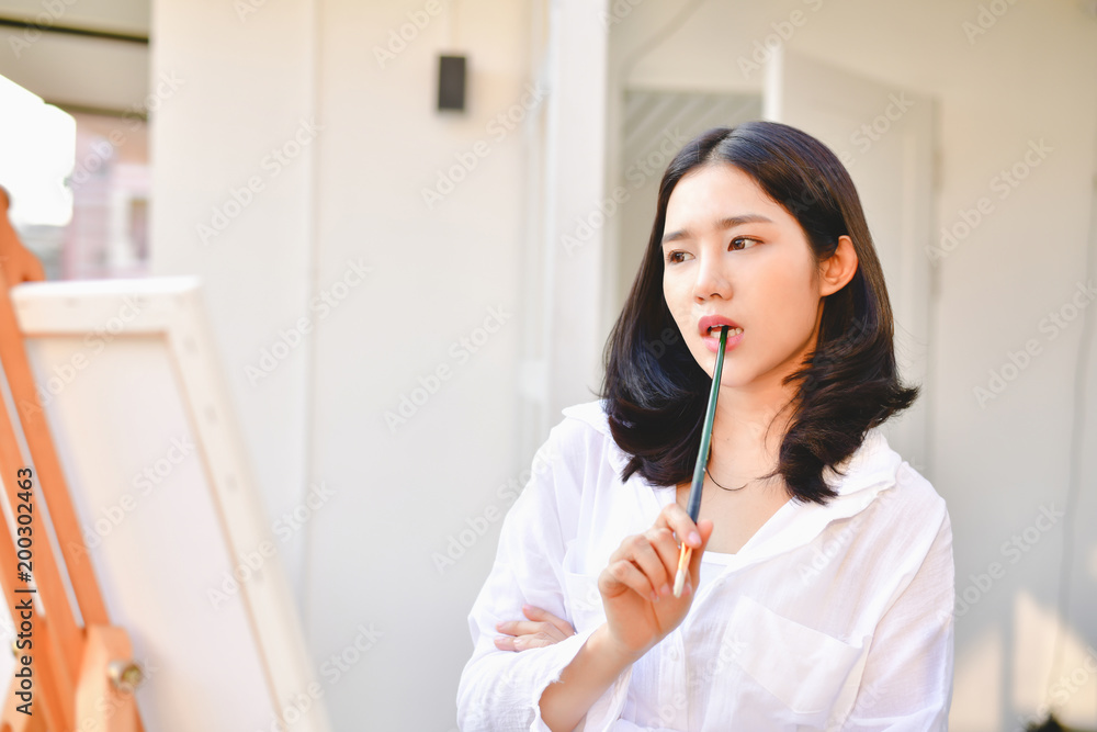 Concept Artist Beautiful girl. Beautiful women are creating art. Beautiful woman is painting happily. Young artist painting outside the house. Concept Artist Beautiful girl. Beautiful women are creating art. Beautiful woman is painting happily. Young artist painting outside the house.