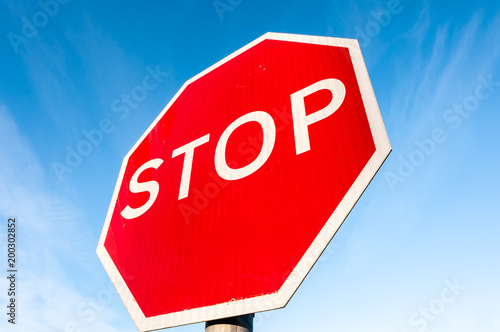 "STOP" road traffic sign against a blue sky