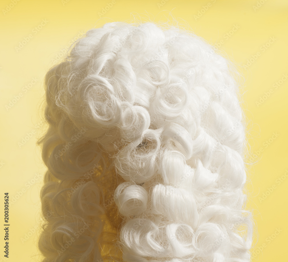 Judge wig on yellow background.