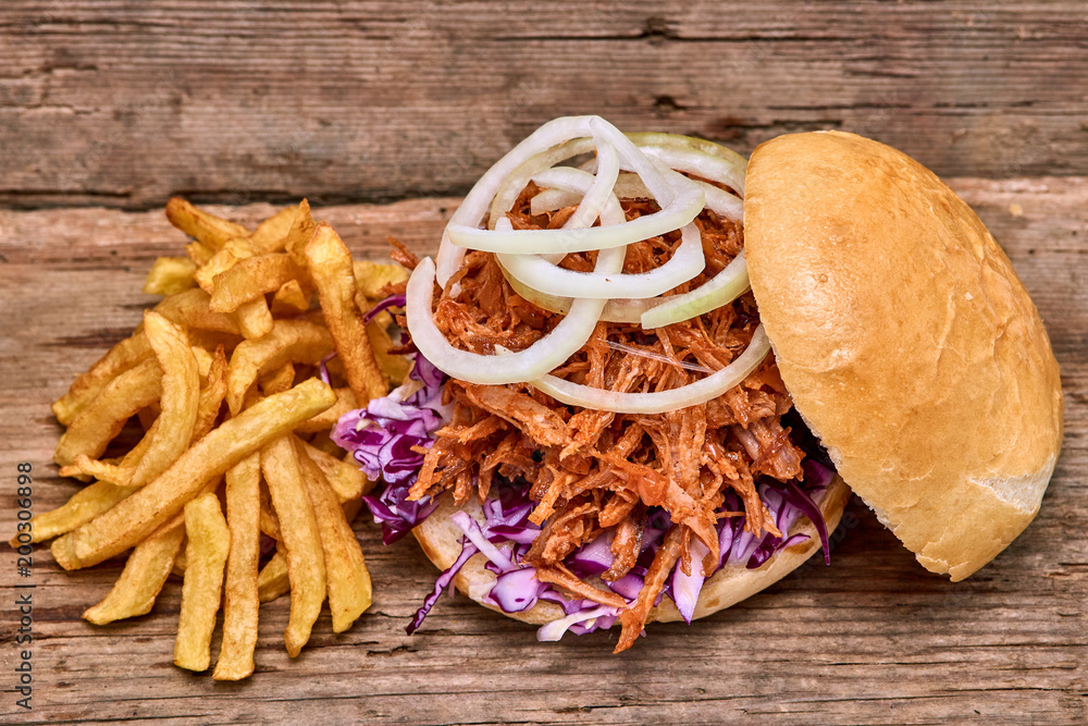 Barbeque Pulled pork Sandwich with BBQ Sauce,salad with red cabbageonion,Sauce and Fries on wooden background,Fast food Barbeque Pulled pork Sandwich with BBQ Sauce,salad with red cabbageonion,Sauce and Fries on wooden background,Fast food