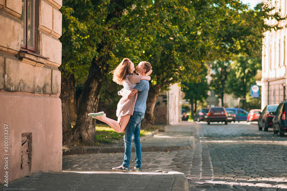 young and beautiful guy and girl kiss each other on the street