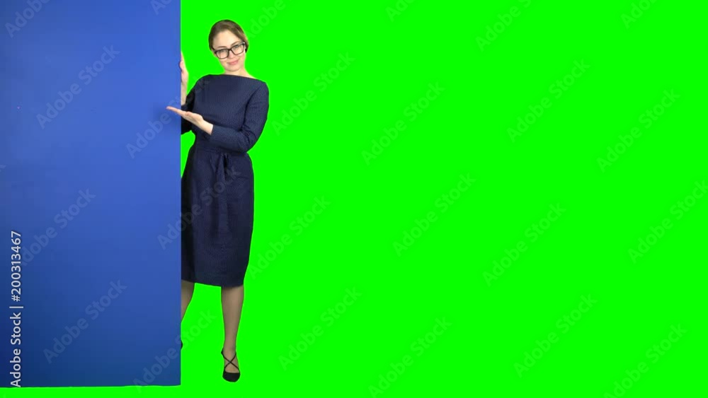 Girl peeks out and points at the billboard. Green screen Girl peeks out and points at the billboard. Green screen