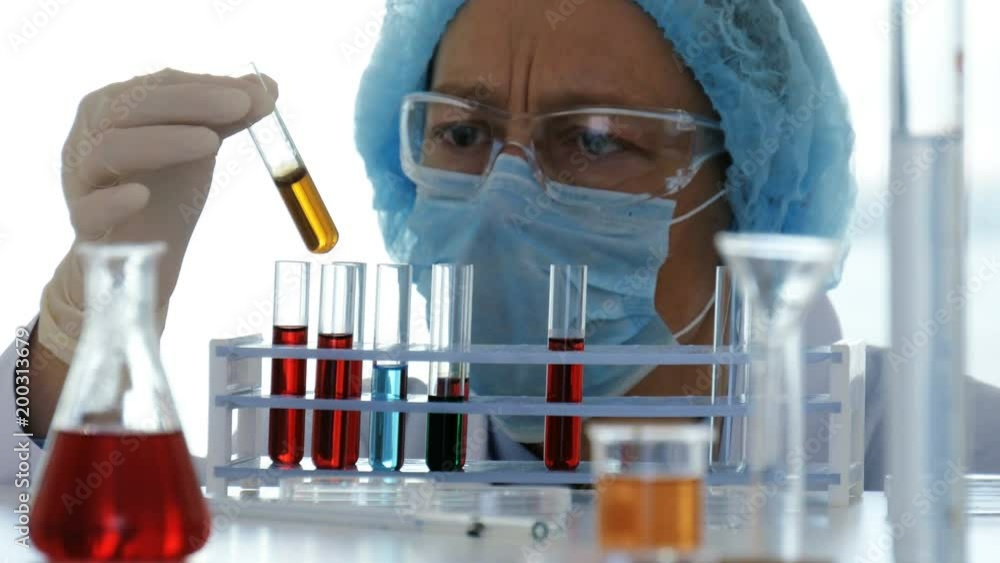 Lab technician controls chemical substances in test tubes Lab technician controls chemical substances in test tubes