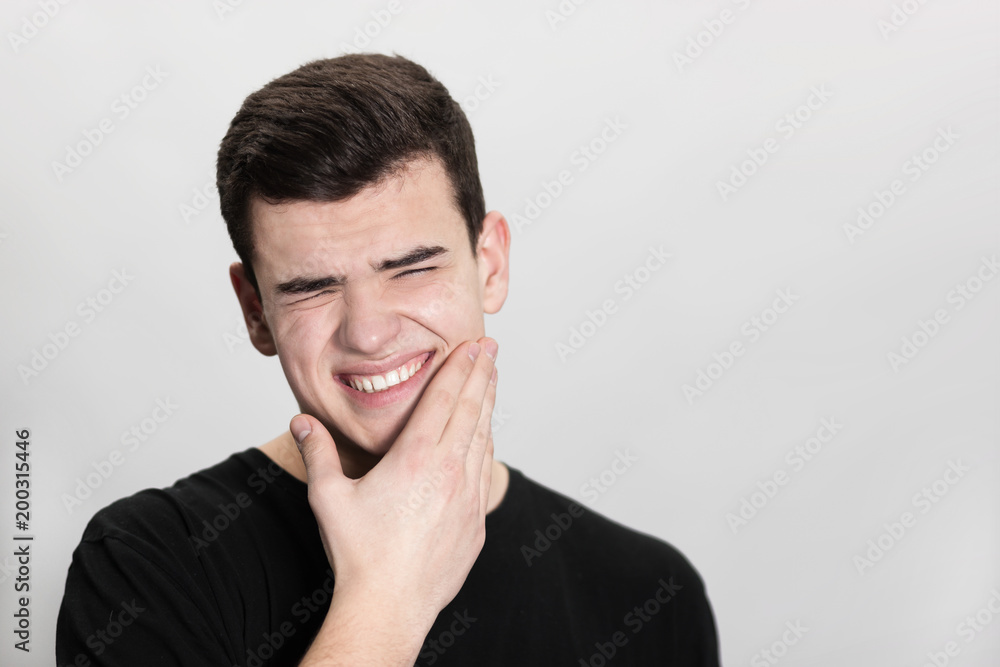 Young man suffering from toothache on white background Young man suffering from toothache on white background