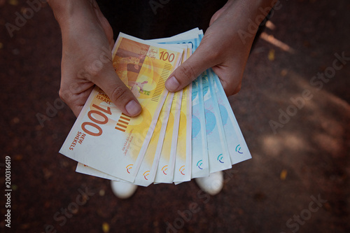 caucasian woman counting New Israeli Shekel banknotes.Concept of Finance,Pension Plans and Pension Funds photo