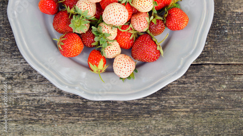 Pineberry and strawberry on the wooden old background photo