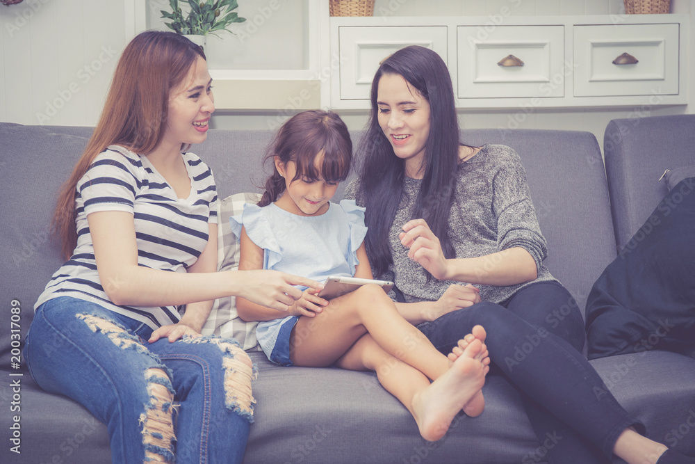 Mother, Aunt and kid having time together lerning with using tablet at home with relax and happy on couch, education and lifestyle concept. Mother, Aunt and kid having time together lerning with using tablet at home with relax and happy on couch, education and lifestyle concept.