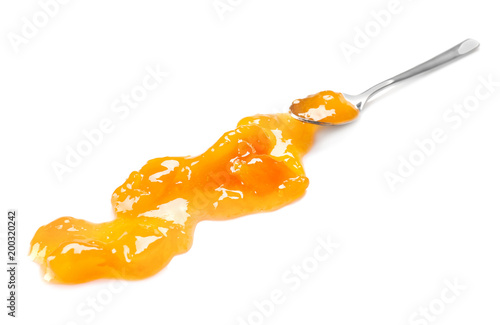 Spoon with sweet jam on white background photo