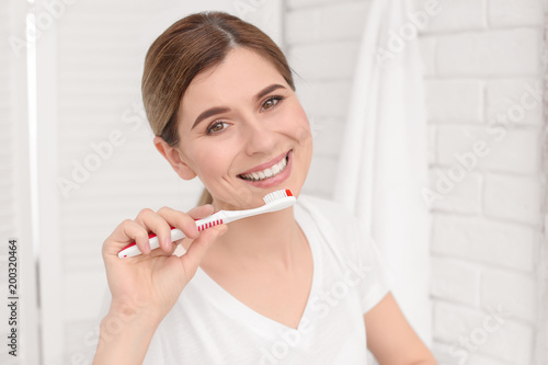 Young woman brushing her teeth indoors