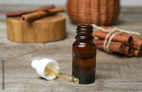 Closeup of bottle with cinnamon oil on wooden table