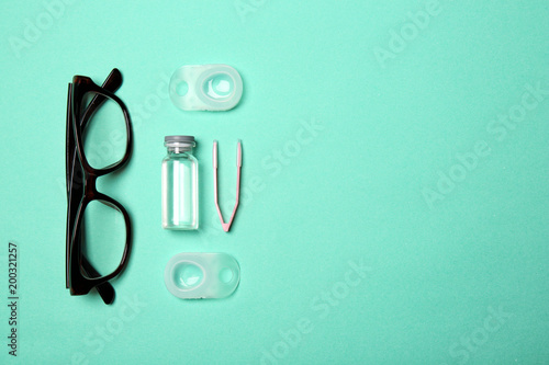 Flat lay composition with glasses, contact lenses and accessories on color background