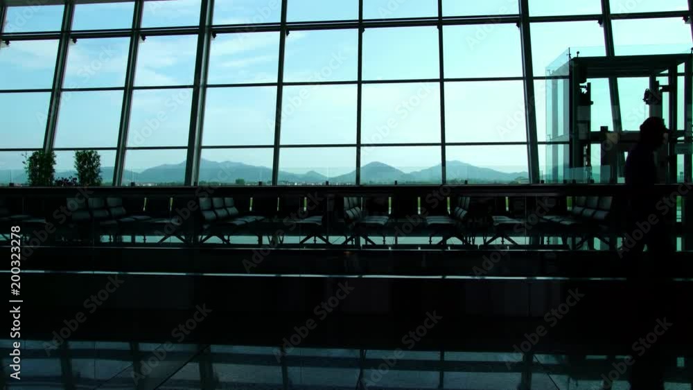 Silhouette of businessman passengers walking in the busy airport building Silhouette of businessman passengers walking in the busy airport building