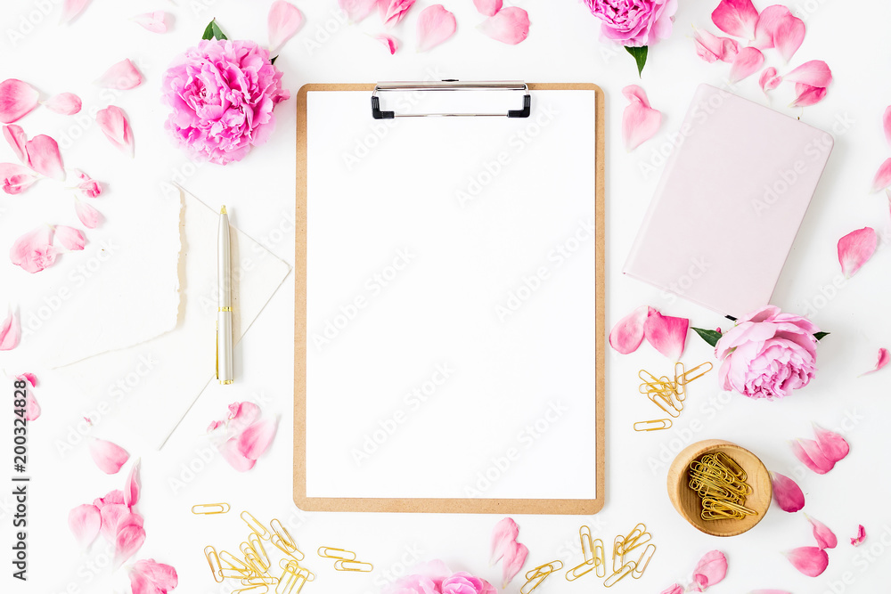 Workspace with clipboard, pastel roses and accessories on white background. Flat lay, top view. Blogger of freelancer concept