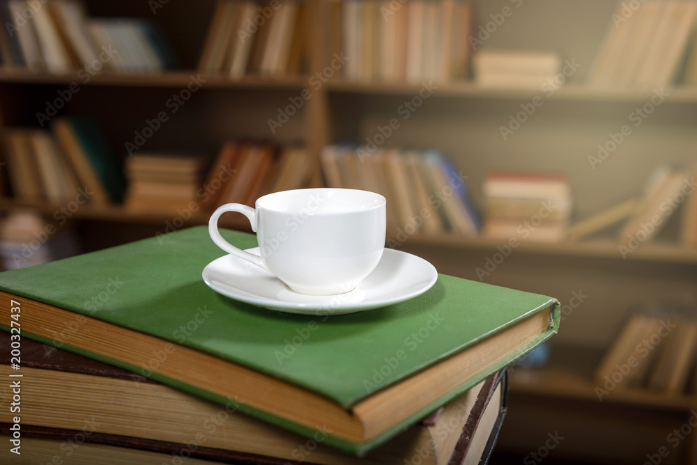 Сup of fresh coffee on a stack of old books in the library Сup of fresh coffee on a stack of old books in the library