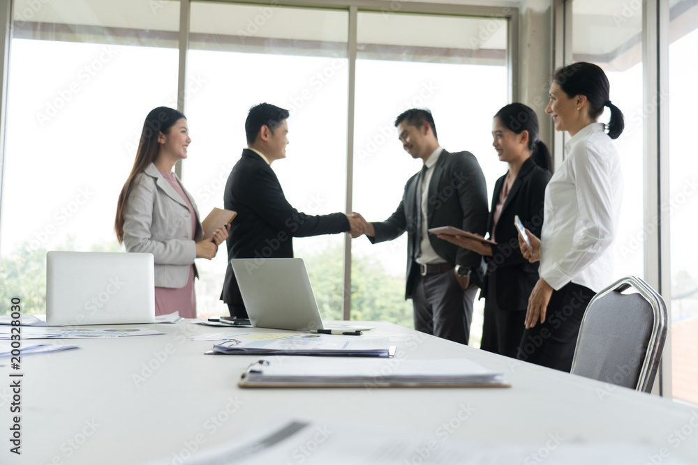 Business people shaking hands, finishing up a meeting in the office.