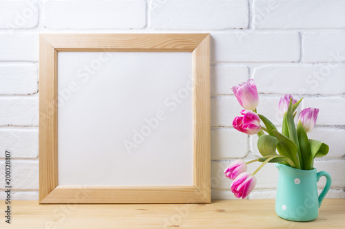 Wooden square frame mockup with pink tulip in mint pitcher vase © TasiPas