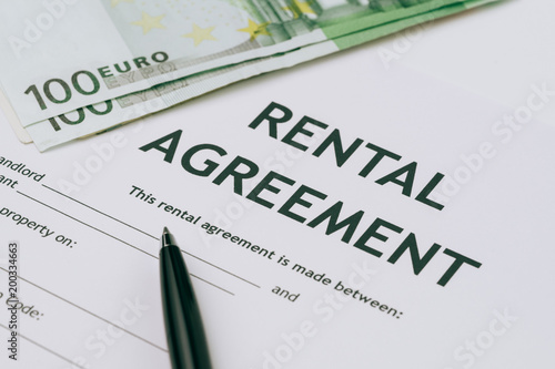 Pen and Euro banknotes money on rental agreement form document, ready to sign contract, property or real estate concept