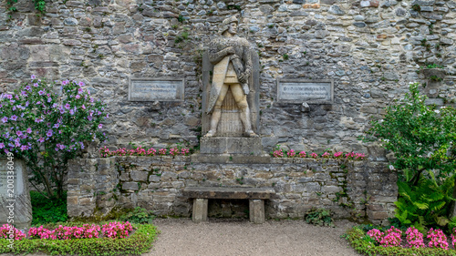 A statue of a warrior sorounded by flowers photo