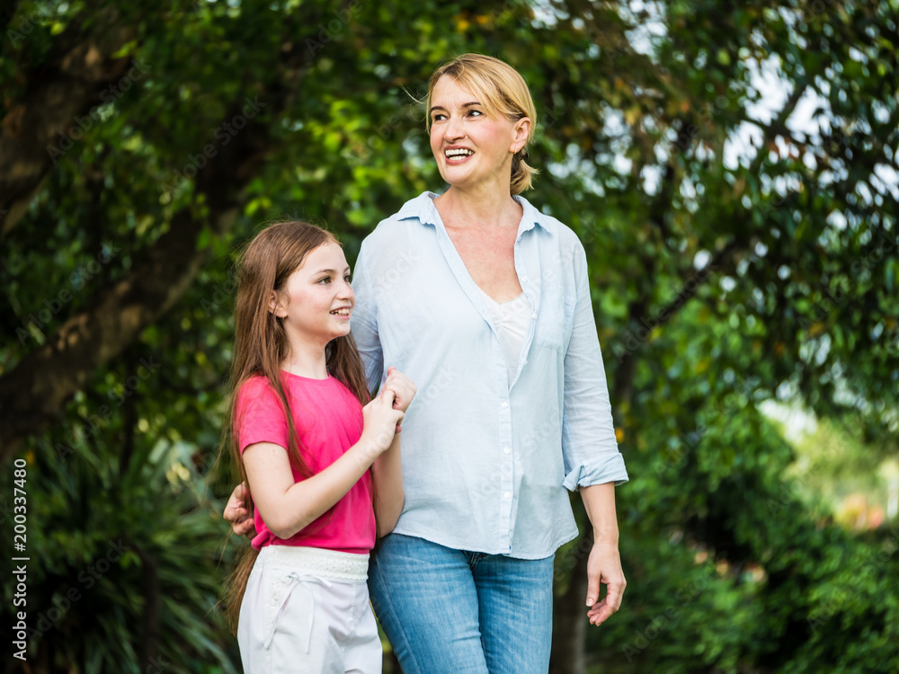 Mother and daughter relaxing walking in a park. Family and lifestyle concept
