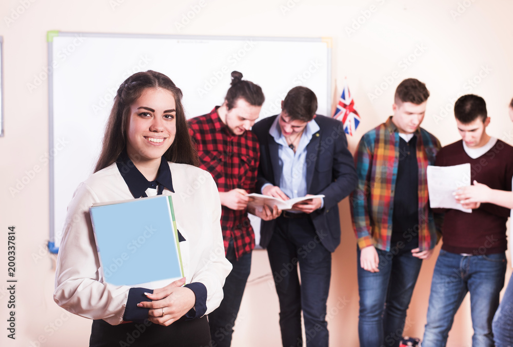 Young people studying with books on white desk. Beautiful girls and guys working together wearing casual clothes. Young people studying with books on white desk. Beautiful girls and guys working together wearing casual clothes.