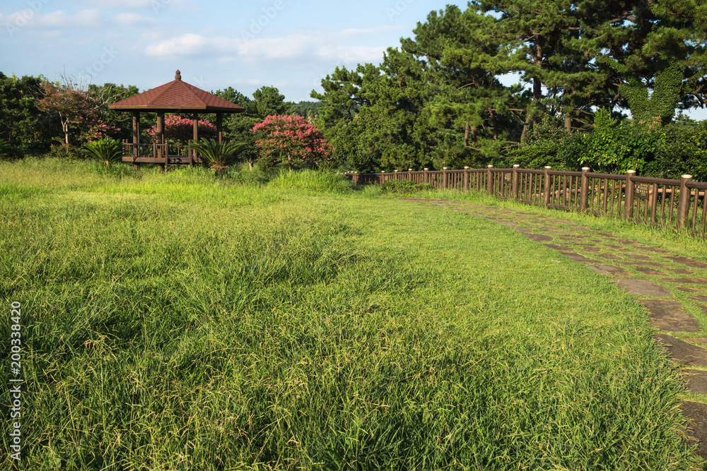 Jeju olle rounded pathway through a park with a little gardenhouse in Seogwipo, Jeju Island, South Korea Jeju olle rounded pathway through a park with a little gardenhouse in Seogwipo, Jeju Island, South Korea