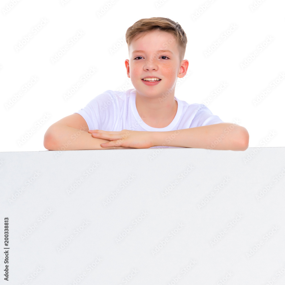 A boy of school age near a white advertising banner. A boy of school age near a white advertising banner.