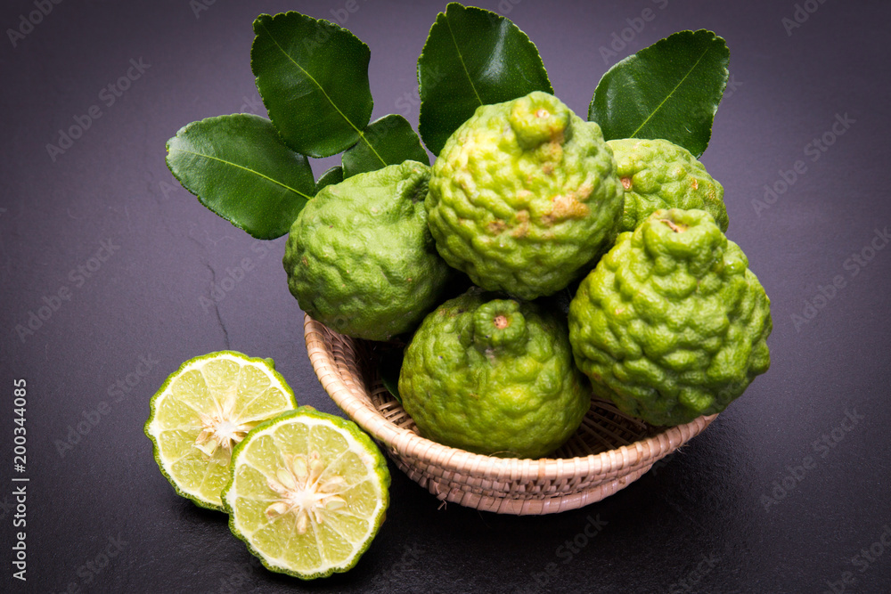 Bergamot, kaffir lime and kaffir lime leaf with basket on dark background Bergamot, kaffir lime and kaffir lime leaf with basket on dark background