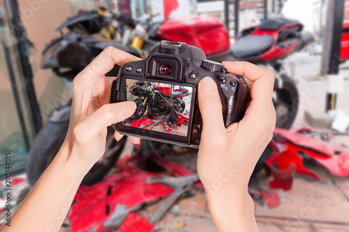 Hands holding the camera at Motorbike accident on the city street
