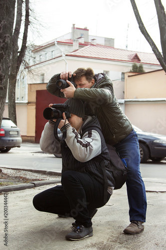 adult men work as photographers in the park