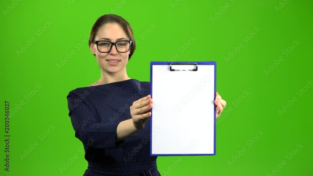 Woman raises a paper tablet and smiles. Green screen Woman raises a paper tablet and smiles. Green screen