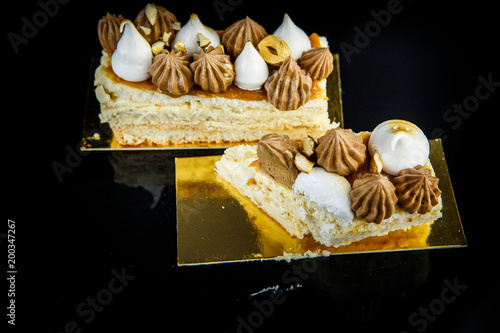 cutted piece of double layer Kiev cake with cream and nuts photo