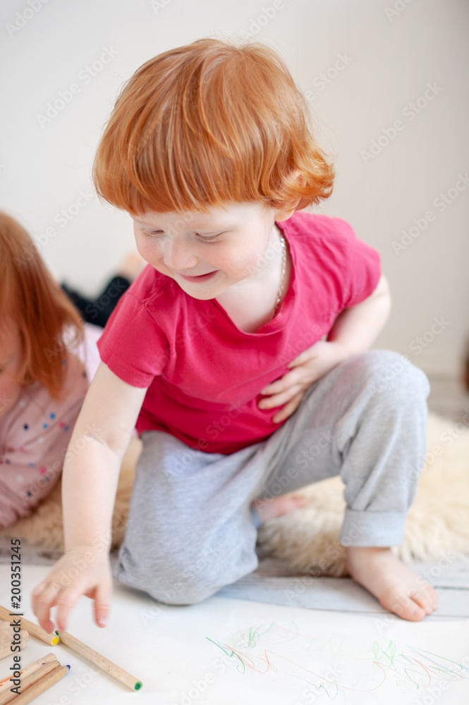 A boy smiling stretches out behind a colored pencil A boy smiling stretches out behind a colored pencil
