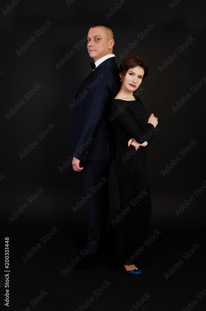 Elegance woman in black evening dress with man in suit posed on studio isolated on black. Duet couple of two. Elegance woman in black evening dress with man in suit posed on studio isolated on black. Duet couple of two.