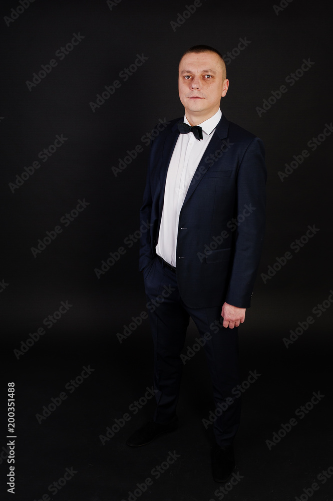 Stylish man in suit posed on studio isolated on black. Stylish man in suit posed on studio isolated on black.