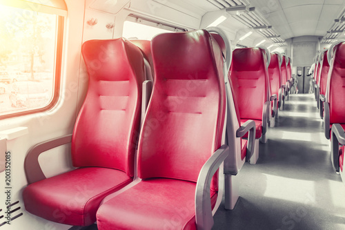 Interior of a passenger train with empty red seats