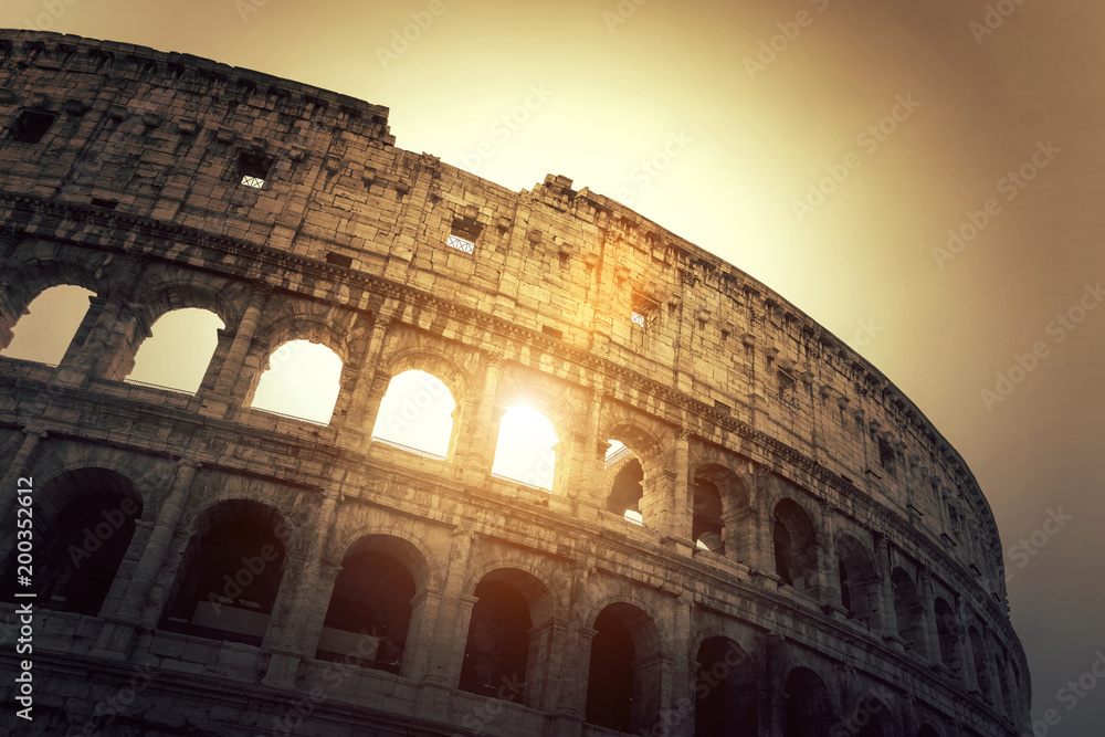 Facade of the famous amphitheater Colosseum in Rome (Italy) during sunset