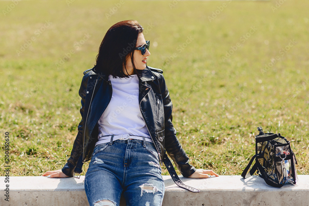 Attractive girl in sunglasses on grass in park Attractive girl in sunglasses on grass in park