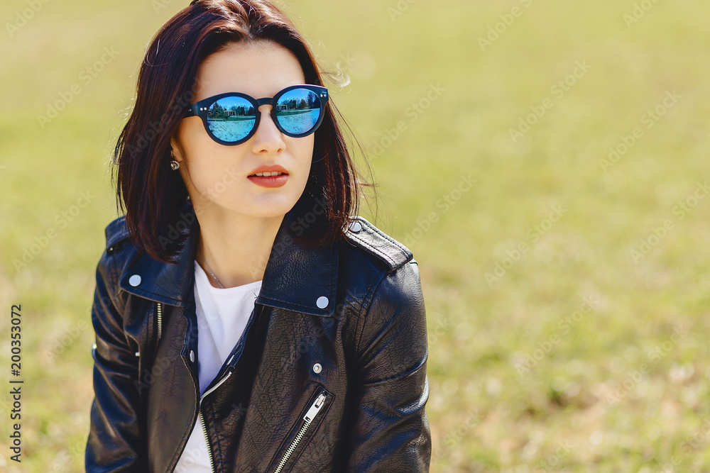 Attractive girl in sunglasses on grass in park Attractive girl in sunglasses on grass in park